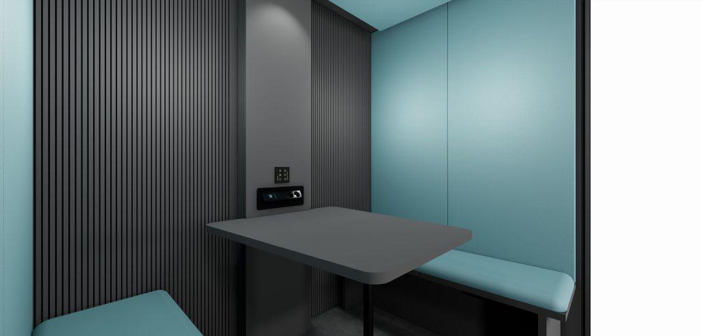 Intérieur cabine acoustique Indus avec table grise et panneaux acoustiques pour environnement industriel