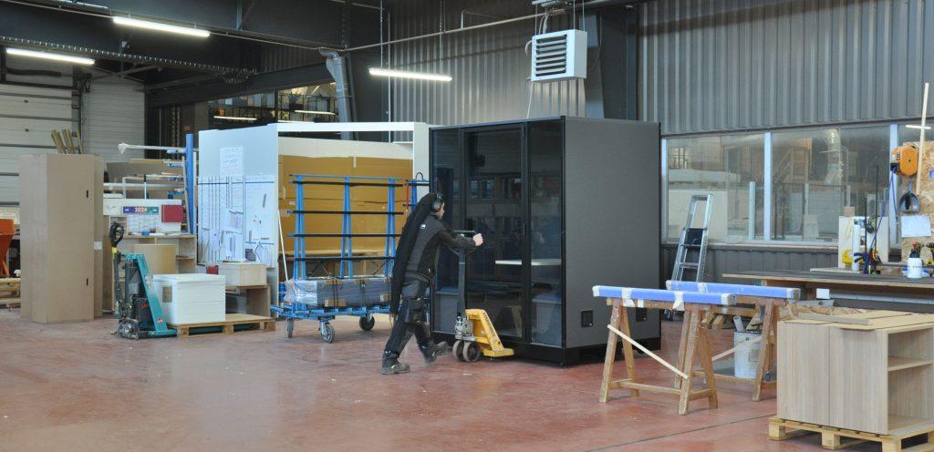 Industrial acoustic booth moved with a pallet jack in a workshop for easy relocation – Blabla-Cube