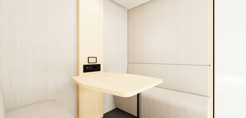 Finition intérieure bois clair dans cabine acoustique avec table et assises
