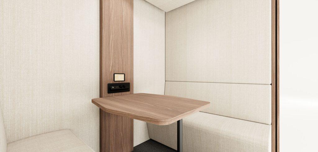 Finition intérieure bois foncé dans cabine acoustique avec table et panneaux acoustiques